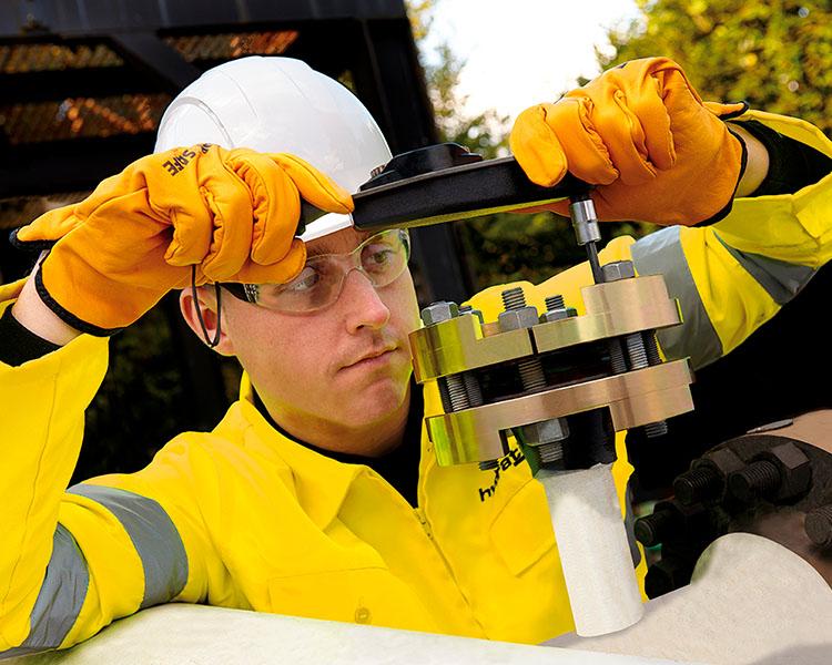 Des travailleurs surveillent des poutres en aluminium avec des étiquettes Featherlite en mouvement sur une ligne de production industrielle dans une usine.
