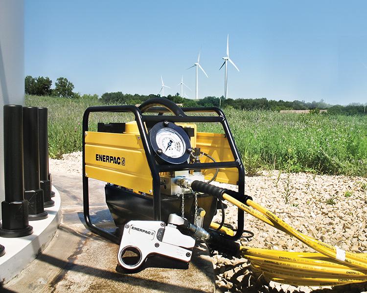 Un travailleur de la construction portant un casque, un gilet de sécurité et une ceinture à outils, se tient fièrement à côté d'un escabeau Featherlite jaune dans un environnement intérieur lumineux.