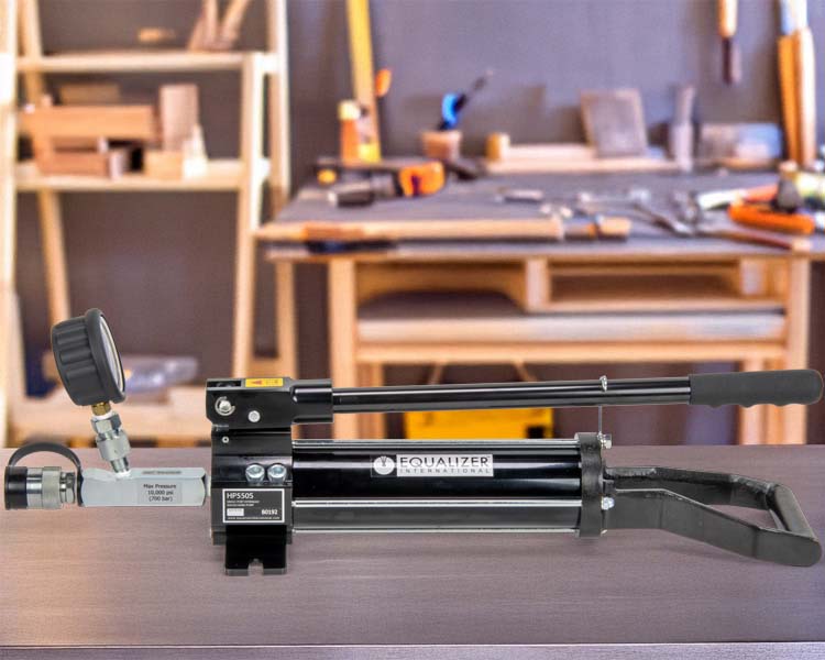 Pompe manuelle Enerpac utilisée pour soulever un équipement lourd dans un atelier de maintenance.